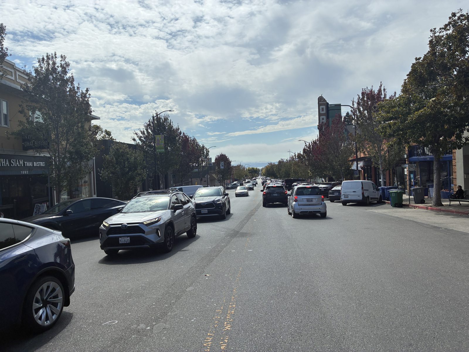 Solano Avenue looking down the street, cars parked on both sides under a clouded sky