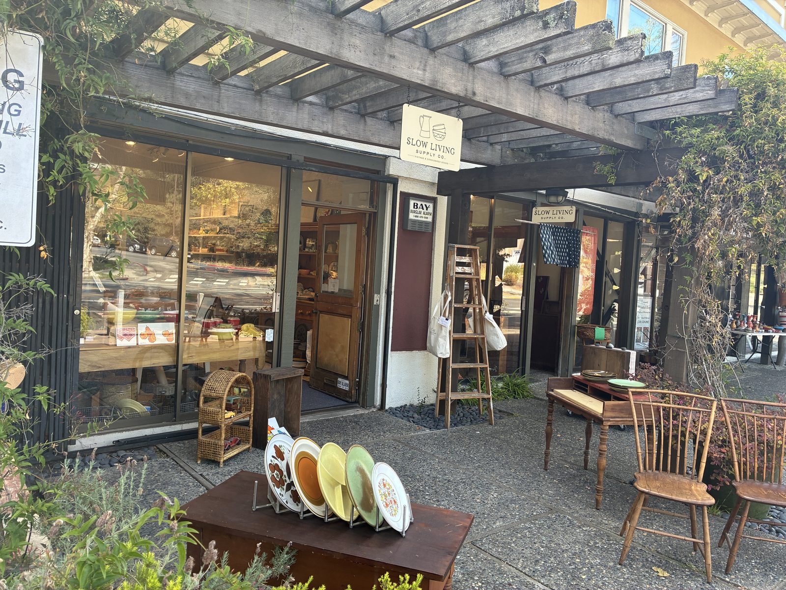 A furniture shop with chairs and a table set out on the sidewalk