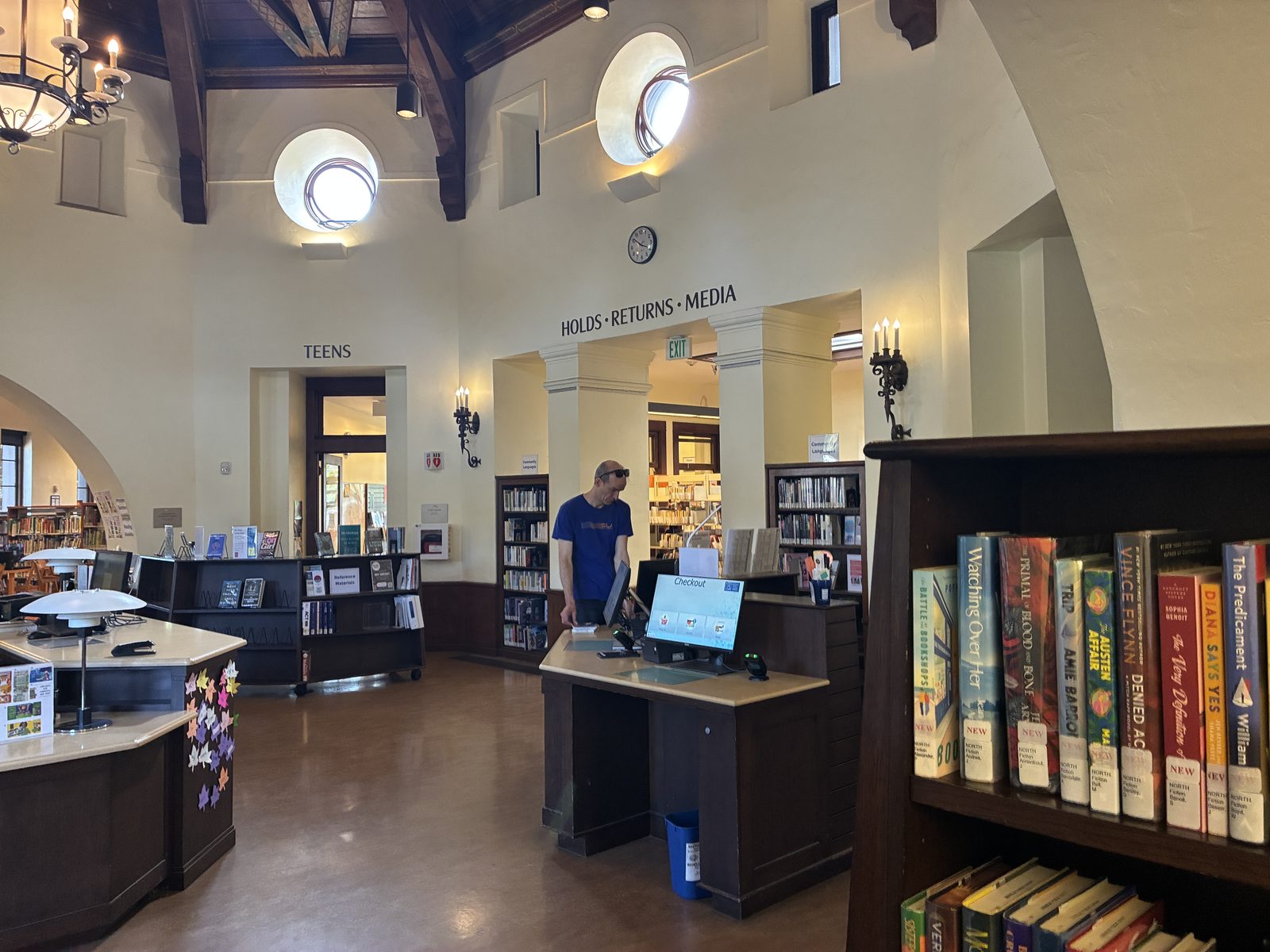 Inside the library, the holds and returns counter under an arched ceiling