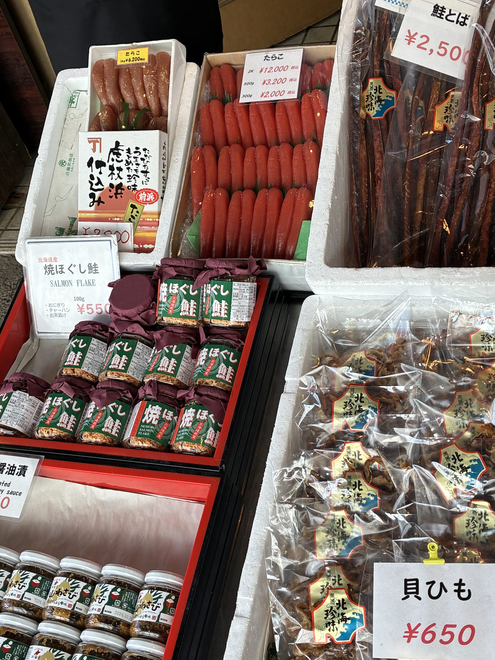 A market stall of salmon products, smoked strips and jars with handwritten prices