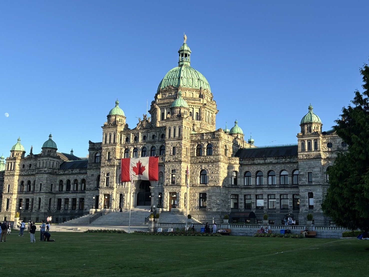 緑のドームのBC州議事堂。正面に大きなカナダ国旗、手前に芝生